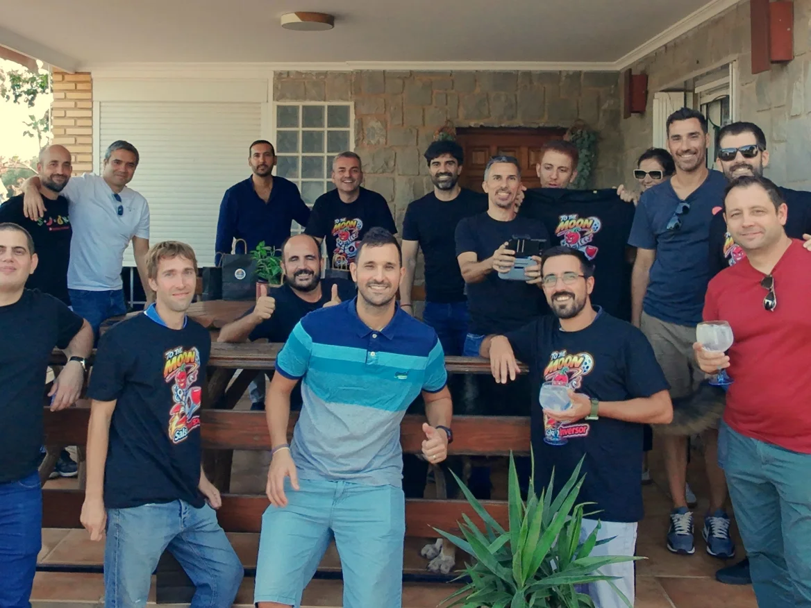 Foto de grupo de la quedada de Salseo Inversor en Valencia: unos quince salseros, muchos con la camiseta «To the Moon», posando en el porche de una casa.