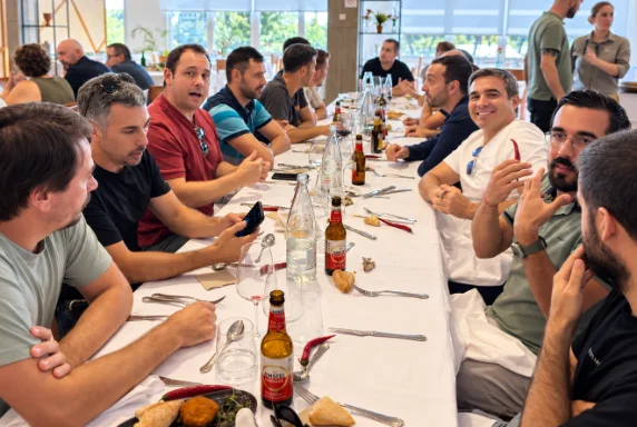 Mesa larga de la comida de la quedada, con los salseros charlando y brindando.